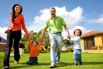 happy healthy family in front of house